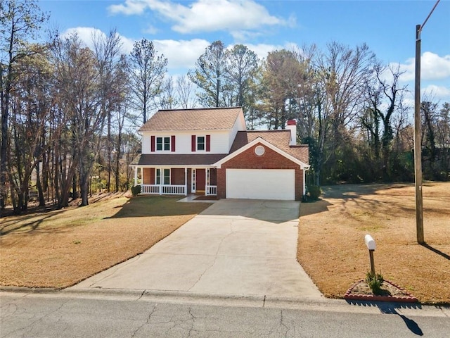 colonial inspired home with covered porch, a front lawn, and a garage