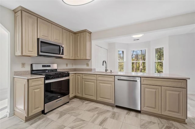 kitchen featuring sink, kitchen peninsula, and stainless steel appliances