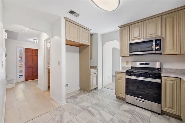 kitchen featuring stainless steel appliances and cream cabinets