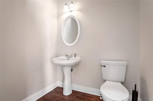 bathroom with hardwood / wood-style floors and toilet