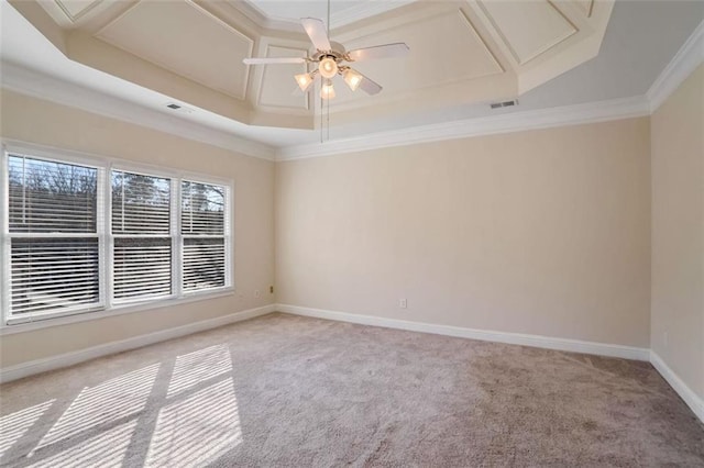 carpeted spare room with a raised ceiling, ceiling fan, crown molding, and coffered ceiling