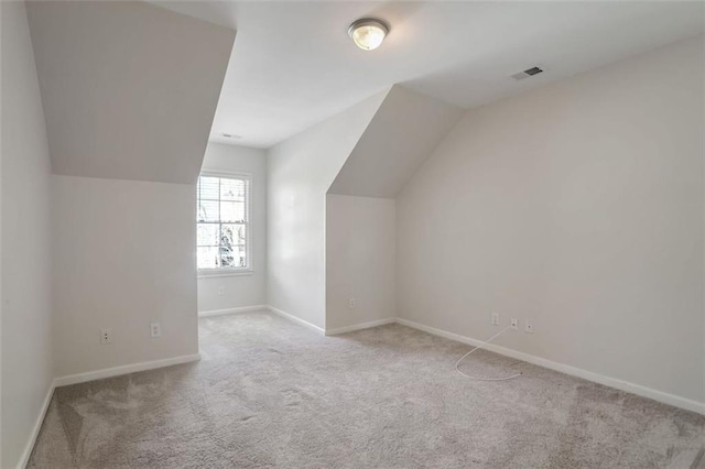 bonus room featuring light carpet and vaulted ceiling