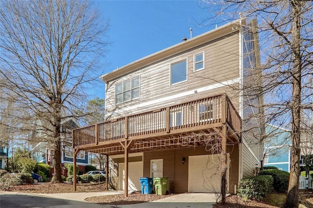 rear view of house with a garage and a deck