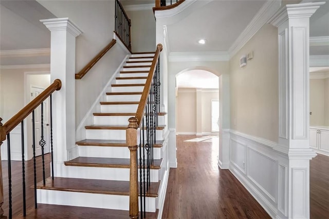 staircase featuring wood-type flooring and ornamental molding