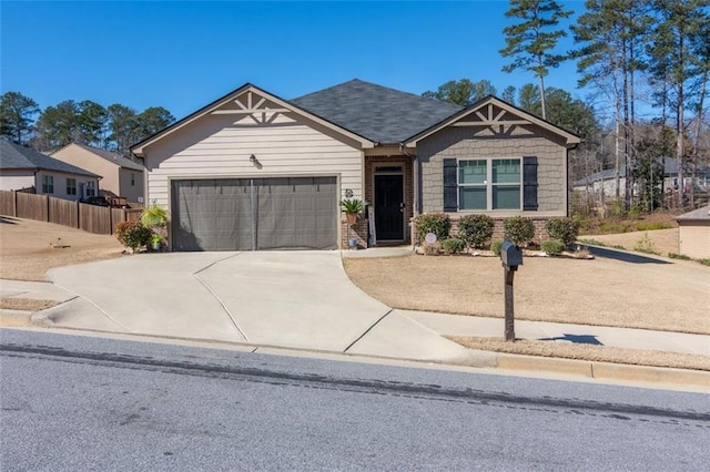 craftsman-style home with a garage, driveway, and fence