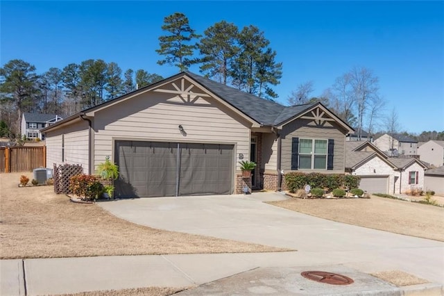 view of front of house with central AC unit, an attached garage, brick siding, fence, and driveway