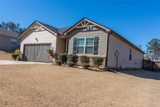 view of front of property with driveway, an attached garage, and fence