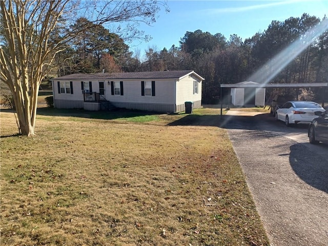 manufactured / mobile home with cooling unit, a front lawn, and a carport