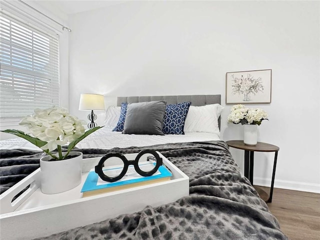 bedroom with baseboards and wood finished floors