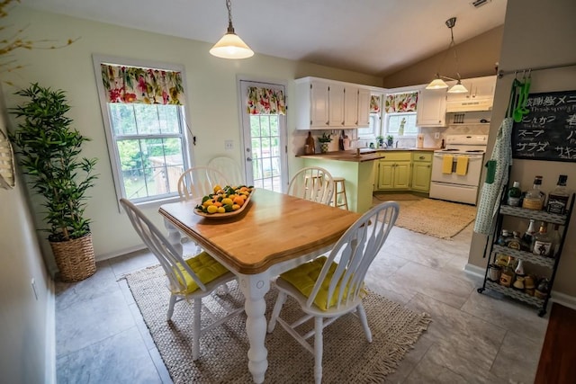 dining space featuring plenty of natural light, vaulted ceiling, and baseboards