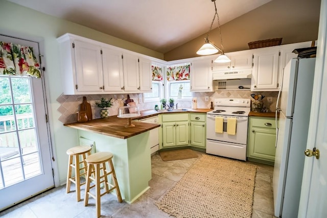 kitchen with white appliances, wood counters, vaulted ceiling, green cabinets, and backsplash
