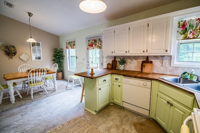 kitchen with dishwasher, healthy amount of natural light, wood counters, and lofted ceiling