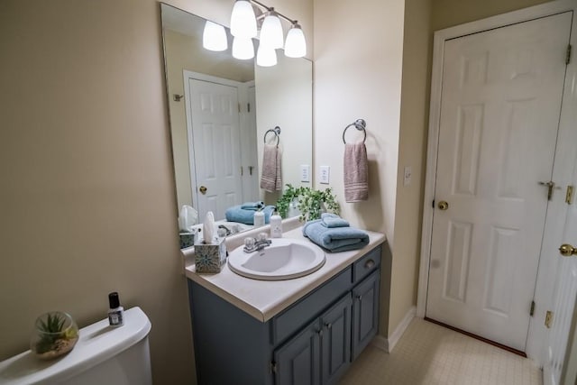 half bath with vanity, toilet, tile patterned flooring, and a chandelier