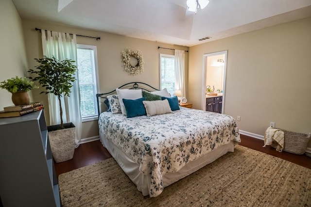 bedroom featuring dark wood-type flooring, baseboards, and multiple windows
