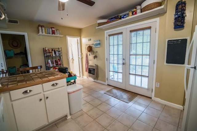 entryway with heating unit, french doors, ceiling fan, and light tile patterned flooring