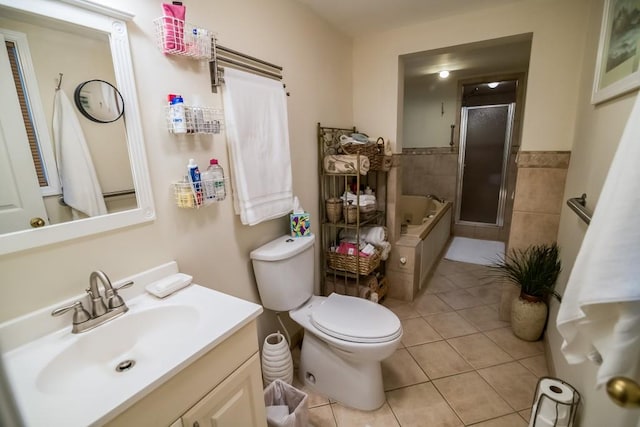 full bath featuring tile patterned floors, a stall shower, vanity, a garden tub, and toilet