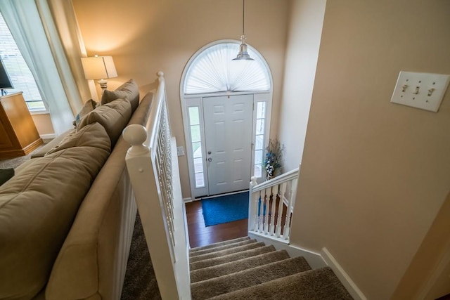 entrance foyer with stairway, baseboards, and wood finished floors