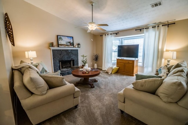 carpeted living area featuring ceiling fan, a fireplace, and baseboards
