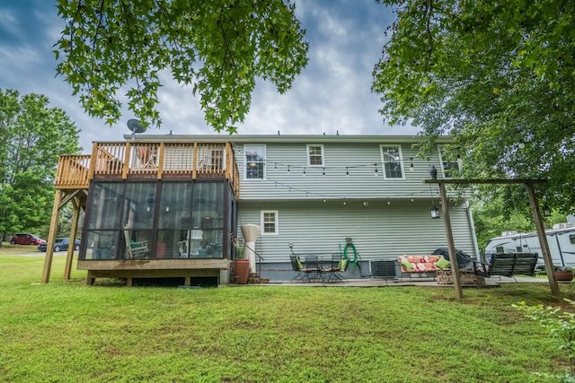 rear view of property featuring a sunroom, a lawn, central air condition unit, and a patio area