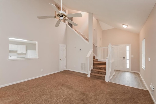 foyer with visible vents, high vaulted ceiling, baseboards, stairway, and carpet