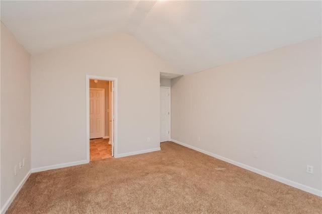 unfurnished bedroom with baseboards, light colored carpet, and lofted ceiling