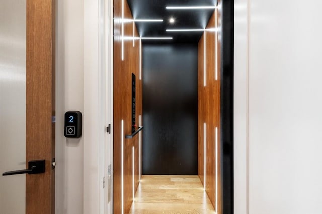 interior space with light wood-type flooring and elevator