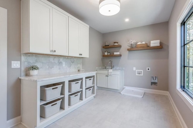 laundry room featuring hookup for a washing machine, cabinet space, hookup for an electric dryer, a sink, and baseboards