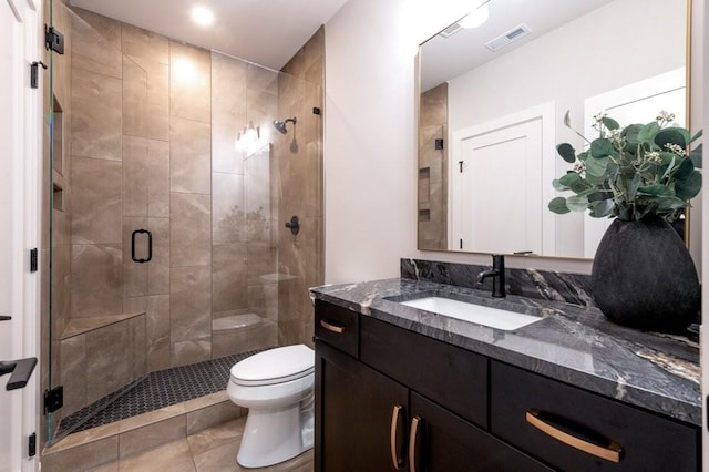 full bathroom featuring toilet, a stall shower, visible vents, and vanity