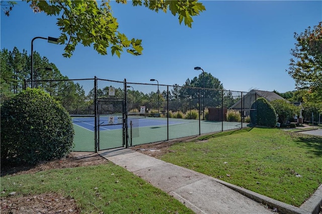 view of sport court featuring a lawn