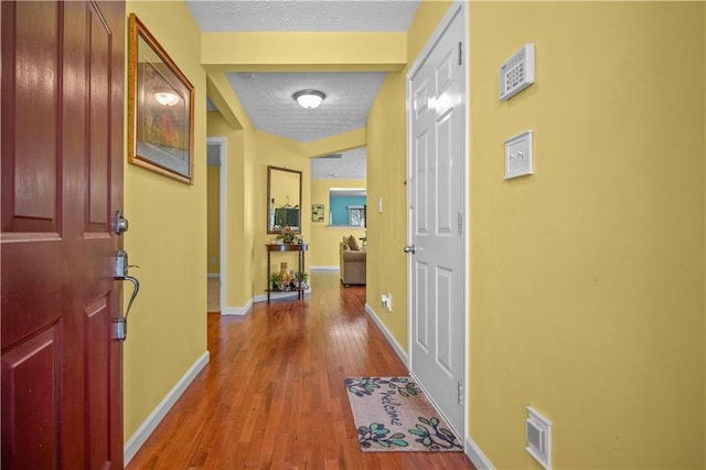 hallway featuring a textured ceiling and hardwood / wood-style floors