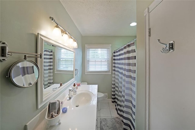 bathroom featuring toilet, curtained shower, a textured ceiling, tile patterned flooring, and vanity