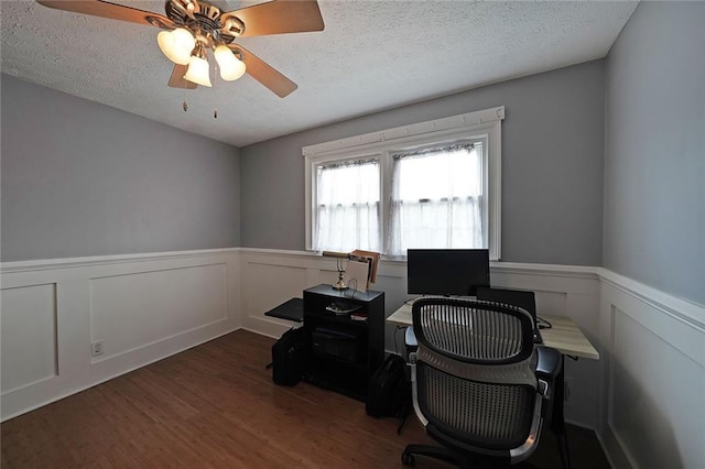 office area featuring wainscoting, a textured ceiling, a ceiling fan, and wood finished floors