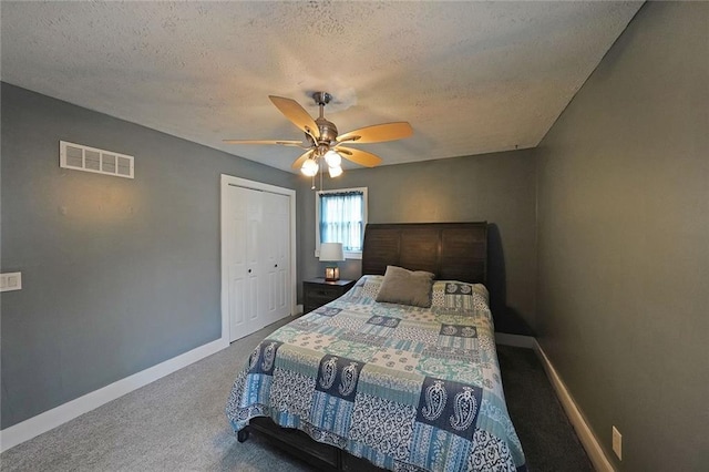 carpeted bedroom featuring a closet, visible vents, a textured ceiling, and baseboards