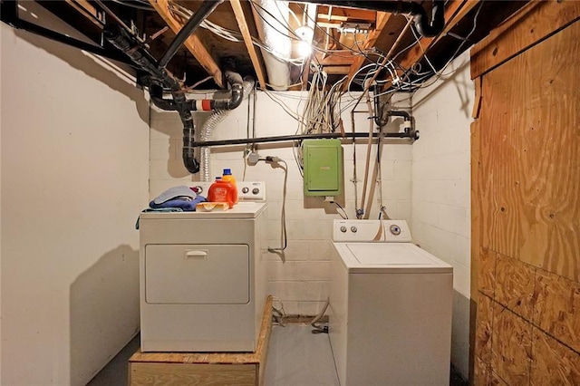 clothes washing area with electric panel, laundry area, and washing machine and dryer