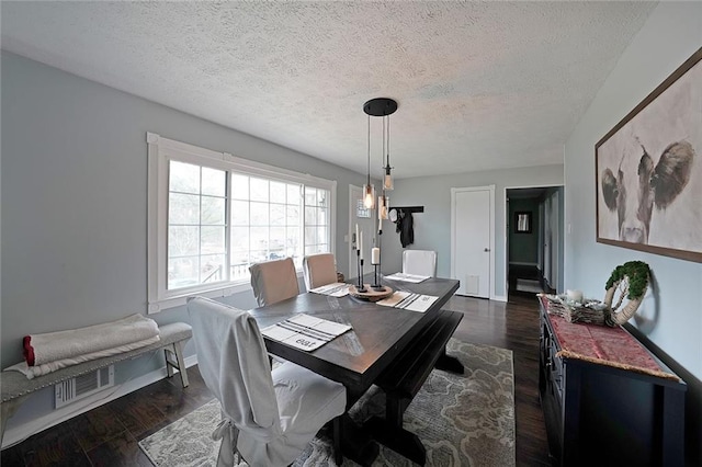 dining space with visible vents, baseboards, dark wood-type flooring, and a textured ceiling