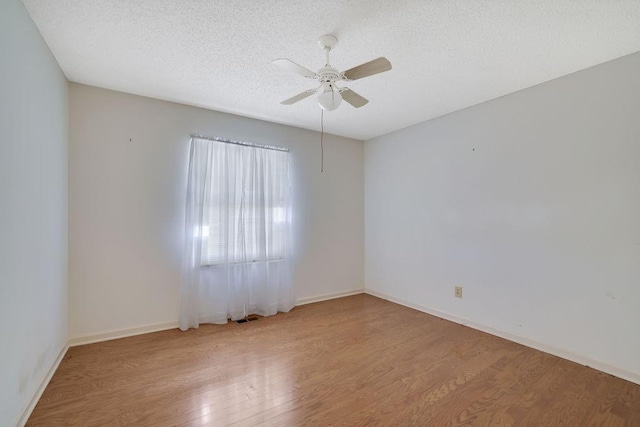 spare room featuring ceiling fan, light hardwood / wood-style flooring, and a textured ceiling