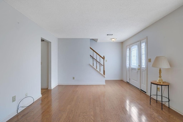 foyer featuring light wood-type flooring and a textured ceiling