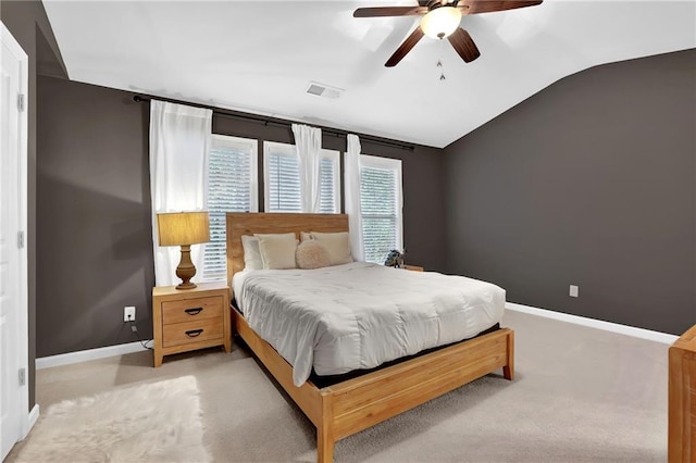 bedroom with baseboards, vaulted ceiling, visible vents, ceiling fan, and light colored carpet