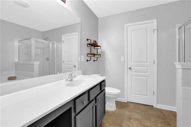 full bathroom with toilet, a stall shower, vanity, and baseboards