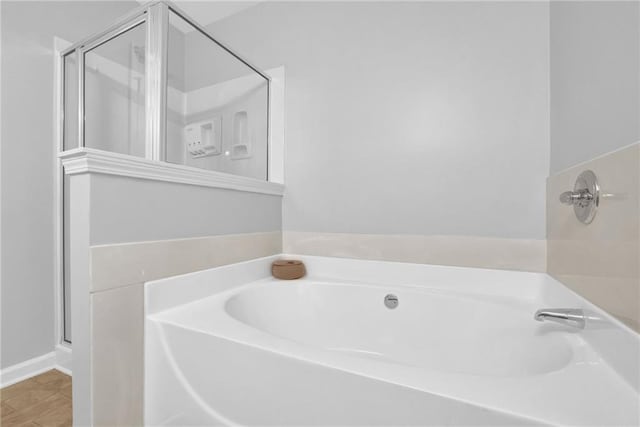 bathroom with a shower stall and a garden tub