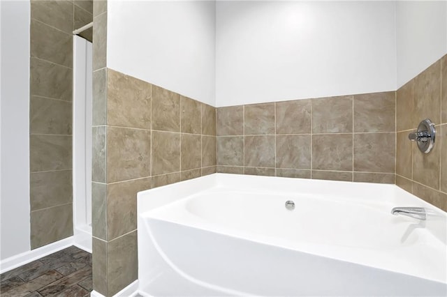 bathroom with tile walls and a bath