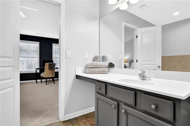 ensuite bathroom with visible vents, baseboards, connected bathroom, and vanity