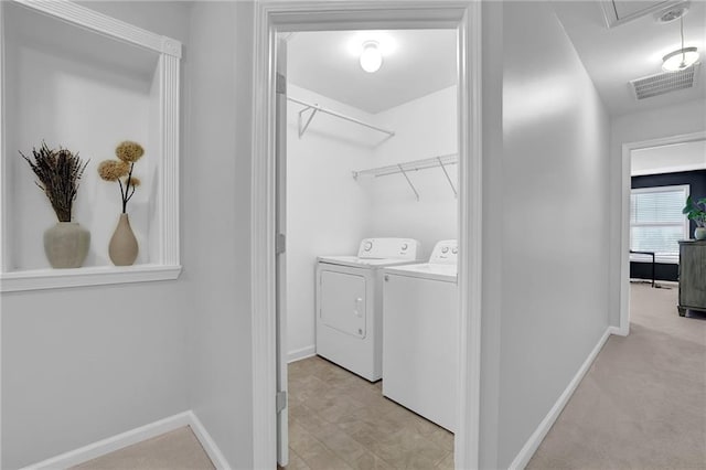 clothes washing area featuring baseboards, visible vents, laundry area, and washing machine and clothes dryer