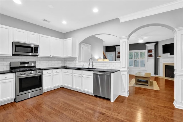 kitchen featuring a sink, visible vents, decorative columns, and stainless steel appliances