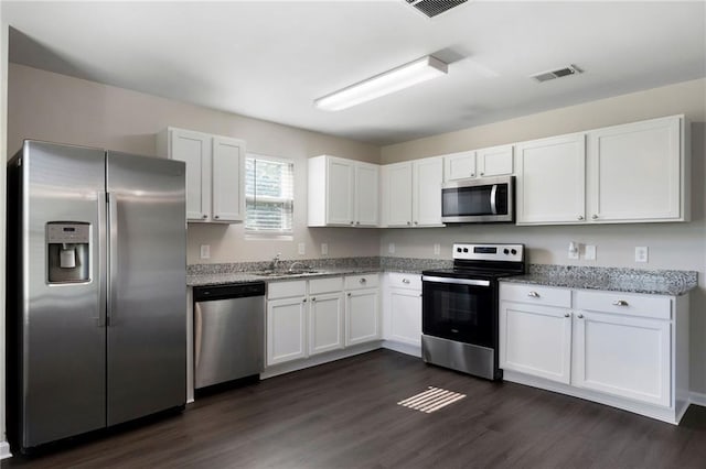 222 Parkland Way, Chatsworth, GA 30705 - kitchen featuring appliances with stainless steel finishes, white cabinets, dark wood-style flooring, and light stone counters
