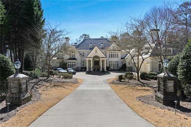 french country home with concrete driveway