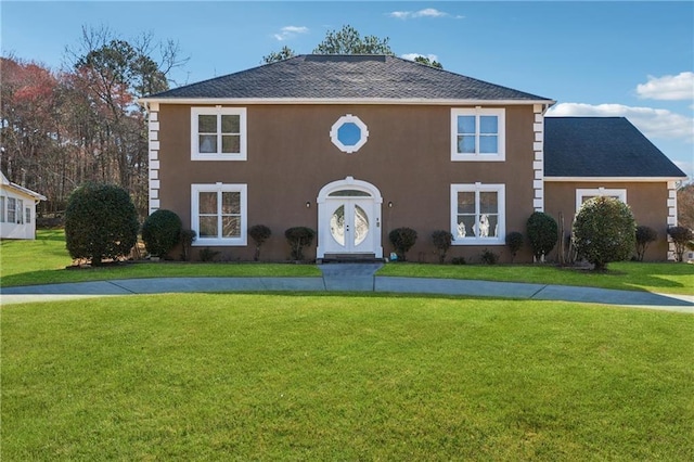 colonial home with stucco siding and a front yard