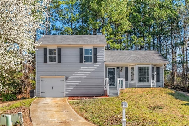 split level home with a front yard, an attached garage, and driveway