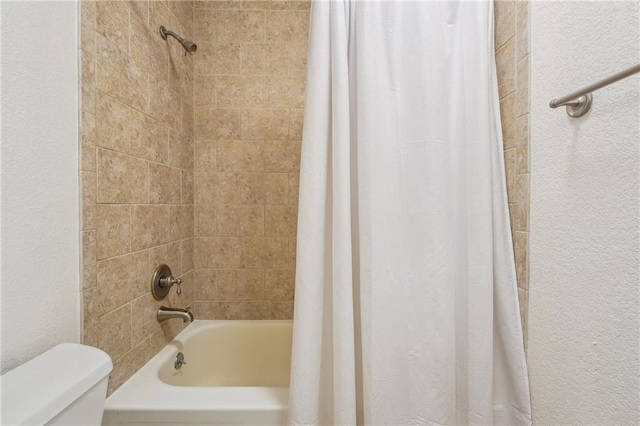 bathroom with shower / bath combo and toilet