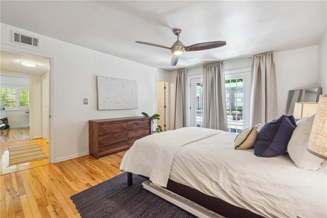 bedroom featuring light wood-type flooring, baseboards, multiple windows, and visible vents